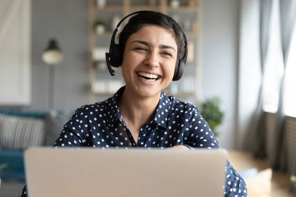 Cheerful indian woman wear wireless headset laughing with laptop — Stock Photo, Image