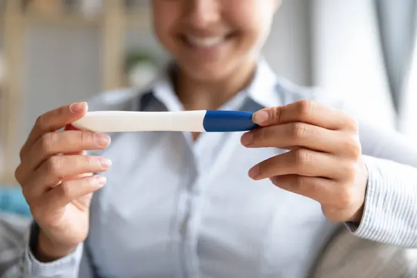 Счастливая беременная женщина держит тест на беременность в руках, вид крупным планом — стоковое фото