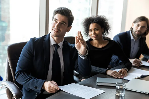 Motivated male employee raise hand participate in team discussion — Stock Photo, Image