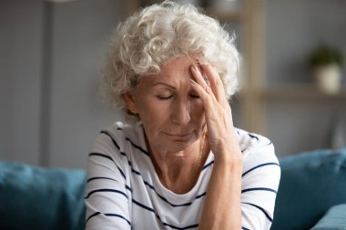 60 'ların kadın kapalı gözleri dokunur alnında migren ağrısı vardır.
