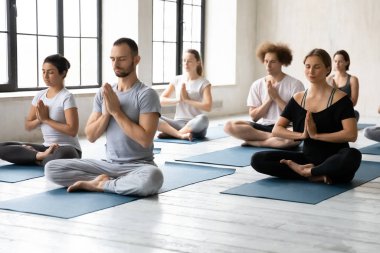Çeşitli insanlar meditasyon yapıyor, Lotus pozisyonunda oturuyor, yoga yapıyor.