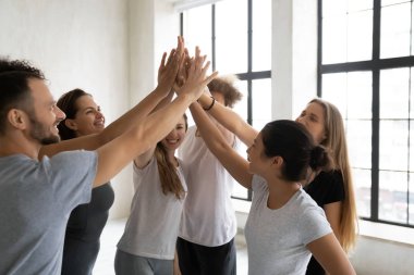 Spor salonunda çeşitli insanlar beşlik çakıyor.