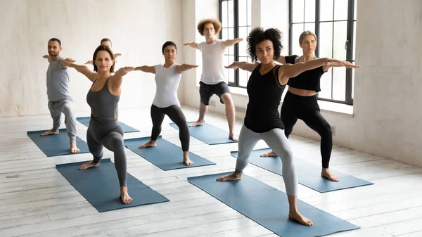 Diverses personnes pratiquant le yoga à la leçon de groupe, Guerrier deux poses — Photo