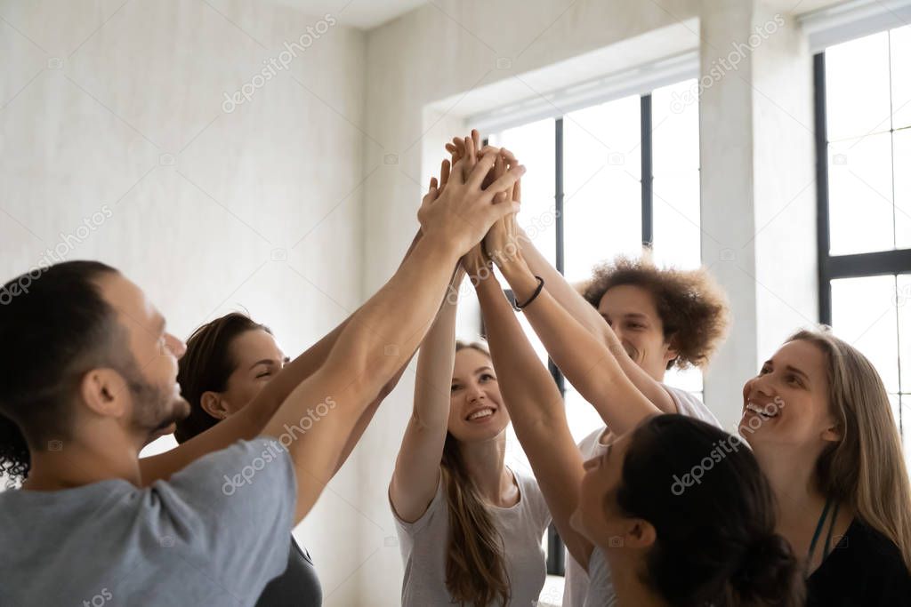 Successful team diverse people giving high five, sharing success