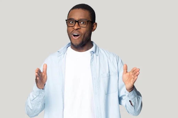 African guy stretched hands showing something long studio shot — Stock Photo, Image