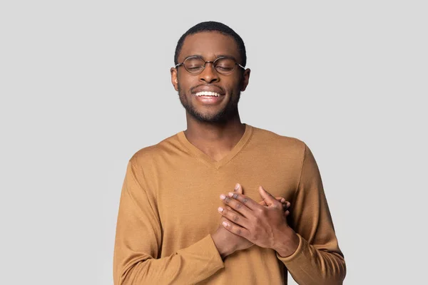 Afrikaanse man houdt handen op de borst tonen dankbaarheid studio schot — Stockfoto