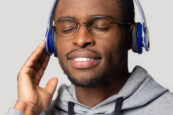 Africano cara usando fones de ouvido azuis ouvir estúdio de música tiro — Fotografia de Stock