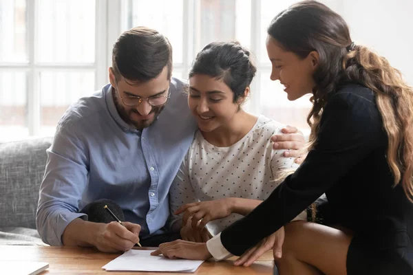 Millennial multiracial couple close deal with banker at meeting — Stock Photo, Image