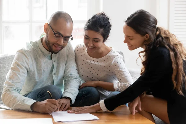 Happy multiracial couple closing deal with female broker — Stock Photo, Image