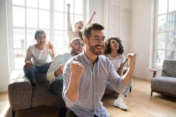 Overjoyed amici multirazziali guardare il calcio a casa online — Foto Stock