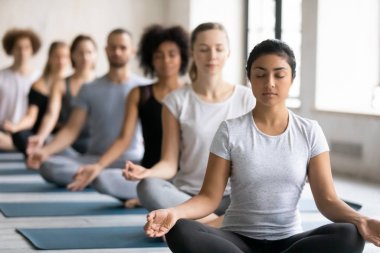 Güzel Hintli kadın grup dersinde meditasyon yapıyor, yoga yapıyor.
