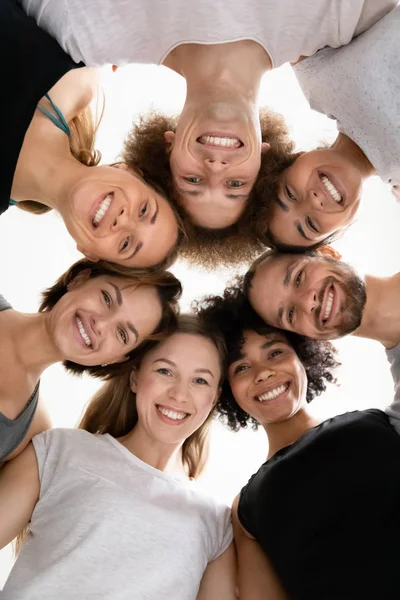 Χαμηλή γωνία χαμογελώντας διαφορετικοί άνθρωποι που στέκονται σε κύκλο, δείχνοντας ενότητα — Φωτογραφία Αρχείου