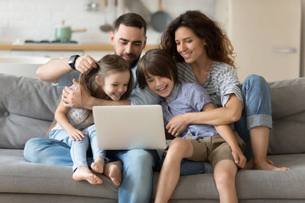 Çocuklu aileler dizüstü bilgisayarlı web sitelerini kullanarak vakit geçirirler. — Stok fotoğraf