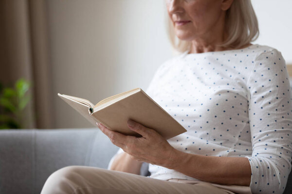 Close up of senior woman reading book at home