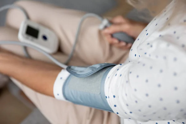 Close up of senior woman measure pressure with tonometer — Stock Photo, Image