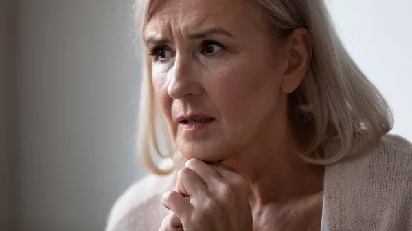 Close-up van verdrietige senior vrouw kijken in afstand denken — Stockfoto