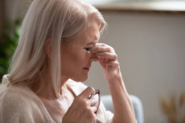 Close-up van zieke oudere vrouw lijden aan wazig zicht — Stockfoto