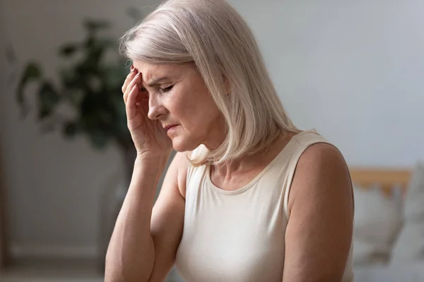 Ongezonde oudere vrouw die thuis migraine heeft — Stockfoto