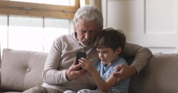 Смешной дедушка и внук звонят на смартфон — стоковое видео