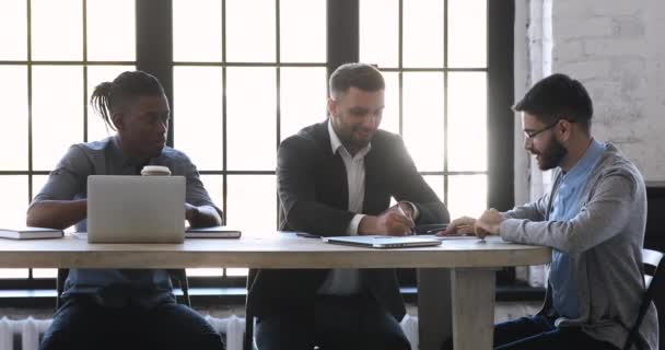 Happy three diverse businessmen team discuss project at office table — Stock Video