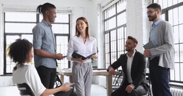 Gelukkig multiraciaal team en vrouwelijke bedrijfsleider praten in werkruimte — Stockvideo