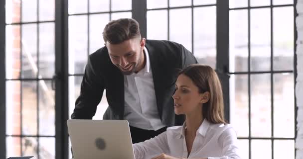 Chefe masculino ajudando empregado feminino com atribuição on-line no escritório — Vídeo de Stock