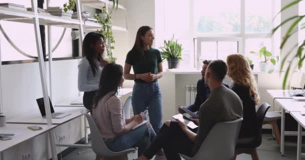 Líder femenina joven discute plan de proyecto con equipo de colegas diversos — Vídeos de Stock