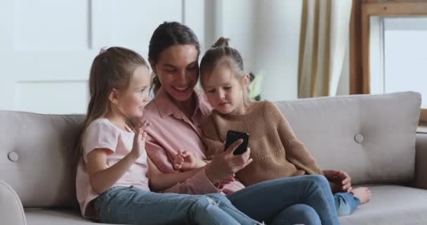 Ευτυχισμένη μαμά χρησιμοποιώντας την εφαρμογή στο smartphone διασκεδάζοντας με τις κόρες — Αρχείο Βίντεο