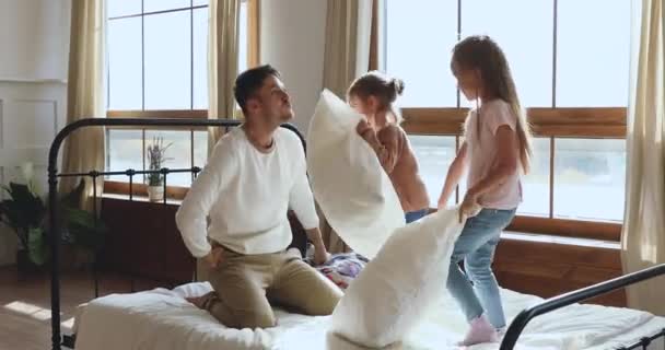 Engraçado pai feliz jogando travesseiro luta com filhas na cama — Vídeo de Stock