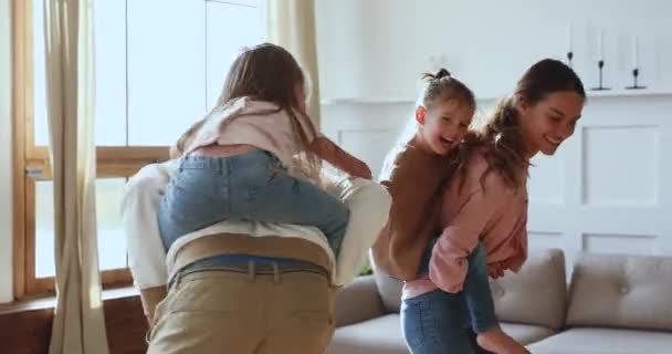 Unbekümmerte Eltern geben lustigen süßen Kindern Huckepack-Fahrt zu Hause — Stockvideo