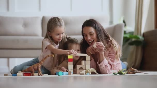 Gelukkig mam babysitter spelen met kinderen bouwen kasteel van blokken — Stockvideo