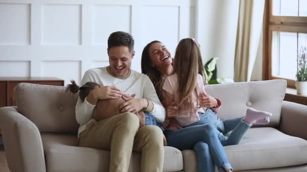 Engraçado família feliz se divertindo cócegas no sofá, câmera lenta — Vídeo de Stock