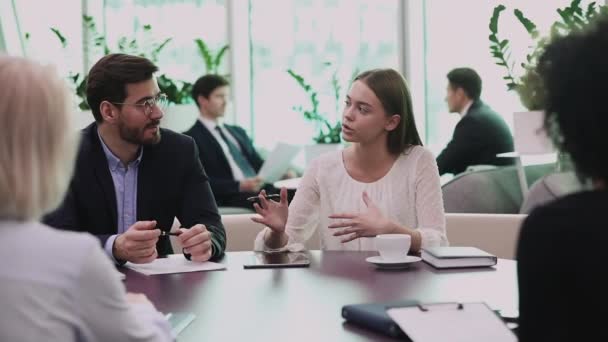 Jovem empresária confiante conversando com diversos colegas de trabalho em reunião de escritório — Vídeo de Stock