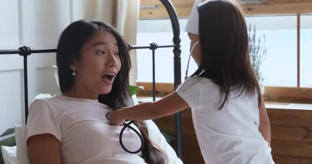 Drôle asiatique enfant fille jouer docteur écoute maman avec stéthoscope — Video