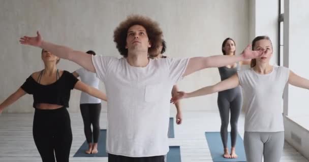 Erkek yoga hocası ve çeşitli insanlar asanas gösterisi yapıyor. — Stok video