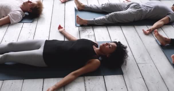 African woman practicing Savasana position during yoga class indoors — Stock Video
