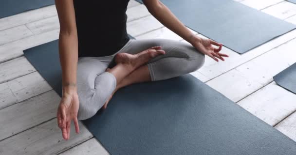 Kapalı görüşlü, meditasyon yapan, bacak bacak üstüne atmış bir kadın. — Stok video