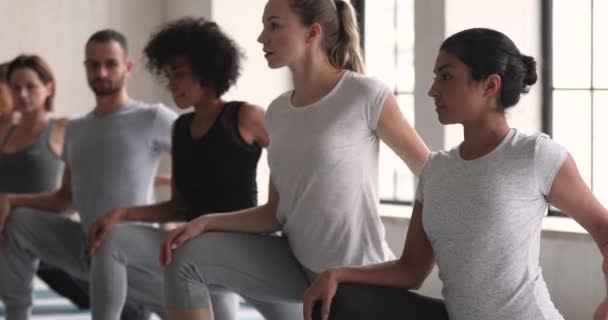 Indisk etnicitet kvinde med andre mennesker, der praktiserer yoga motion indendørs – Stock-video