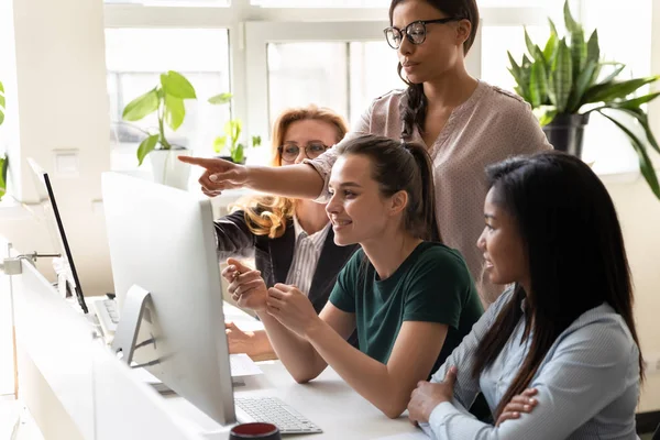 Diverse women coworkers look at computer discuss new common project — Stock Photo, Image