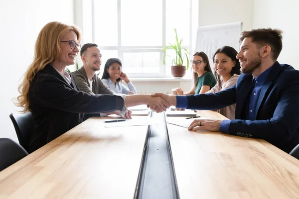 Leaders shaking hands during group meeting in modern board room — Stock Photo, Image