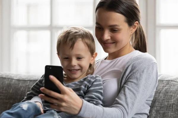 Junge Mutter und kleiner Sohn sehen gemeinsam Video auf Zelle — Stockfoto