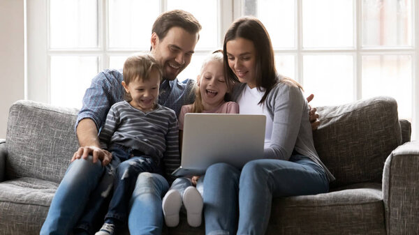 Happy family with kids have fun using laptop together
