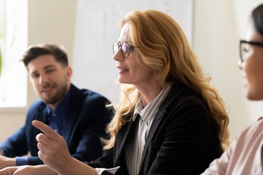 Orta yaşlı akıl hocası grup toplantısında gençlerle konuşuyor