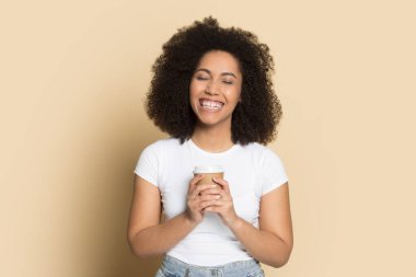 Afrika kökenli Amerikalı kadın elinde bir fincan sıcak kahve tutuyor..