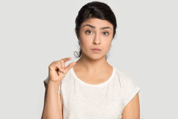 Frustrated millennial indian ethnicity woman demonstrating tiny measurement. — Stock Photo, Image