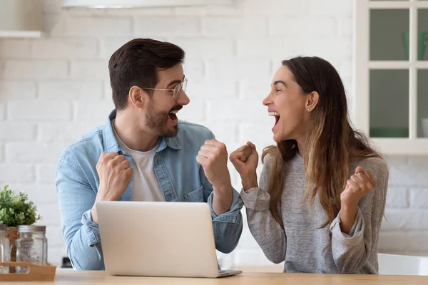 Oververheugd jonge familie echtgenoot vieren online loterij te winnen. — Stockfoto