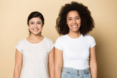 İki mutlu çok ırklı kadın yan yana duruyor..