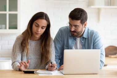 Konsantre genç evli eş aylık aile bütçesini birlikte hesaplıyor.