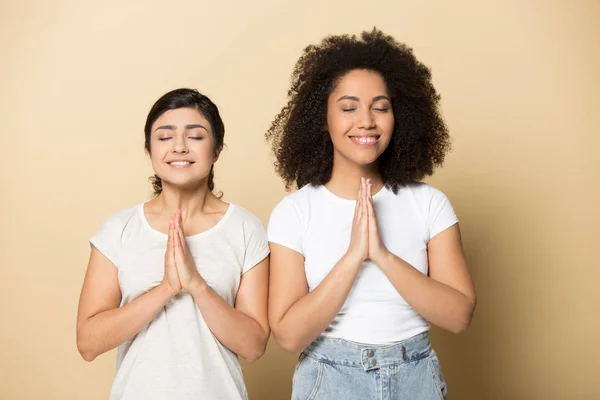 Faithful multicultural female friends praying for good luck. — Stock Photo, Image