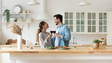 Mutlu melez genç bir kadın Erkekle kadeh tokuşturuyor.